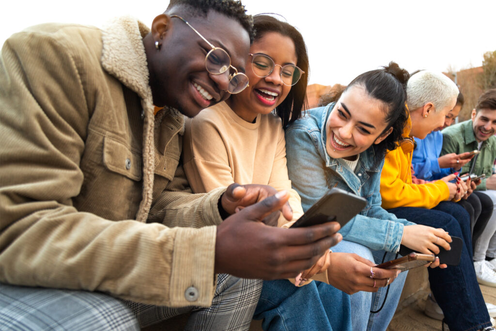 Diverse group of young adults engaged with cell phone